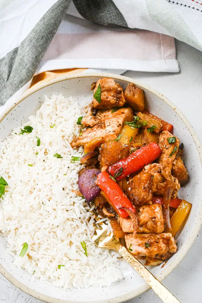 pineapple chicken plated in bowl with rice and fork.jpg