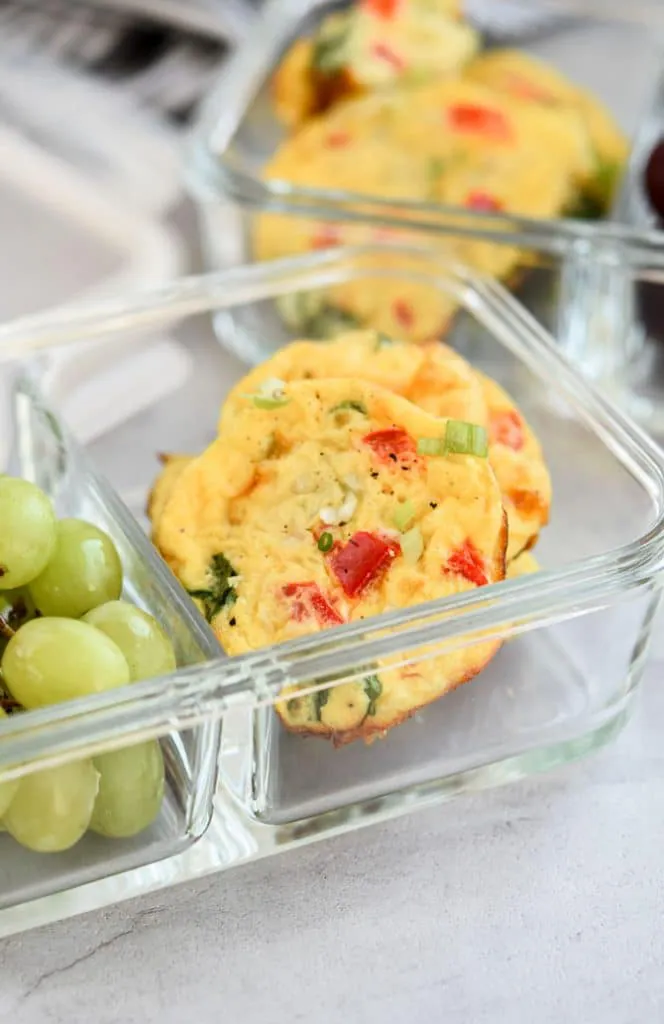 Baked Cottage Cheese Egg Muffins in meal prep container with grapes