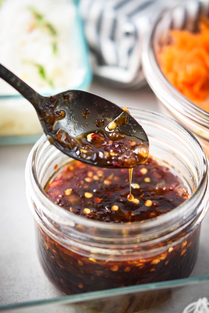 sweet chili sauce on a spoon from a mason jar