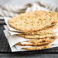 Low carb frozen pizza crusts stacked with parchment separating them