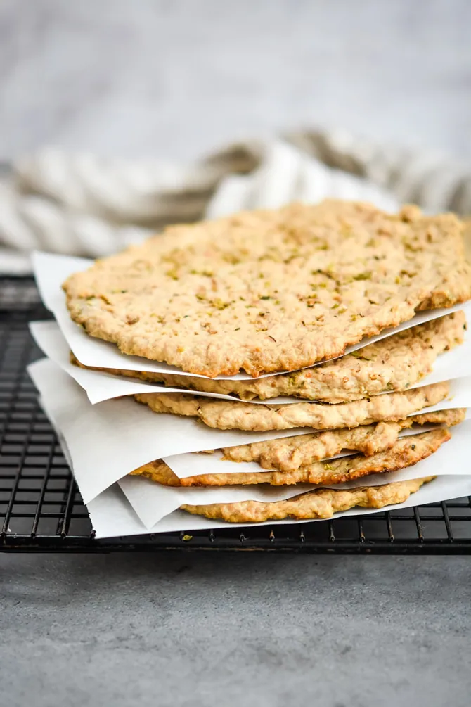 Low carb frozen pizza crusts stacked with parchment separating them