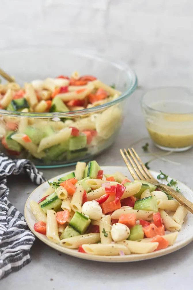 pasta salad plated straight on with bowl in the background