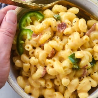 jalapeno bacon mac and cheese in a bowl being held