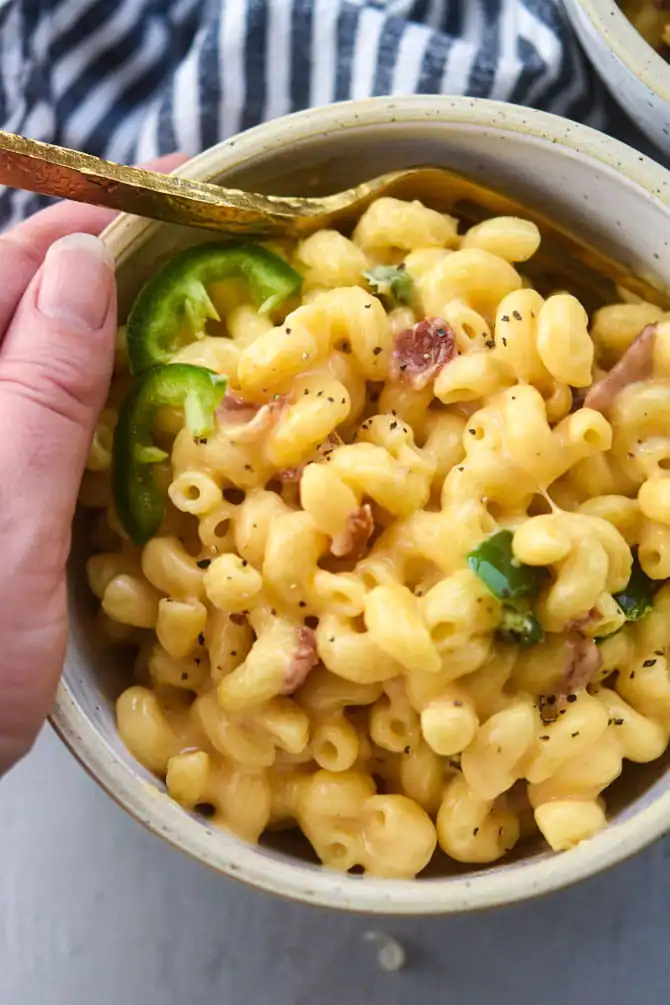 jalapeno bacon mac and cheese in a bowl being held