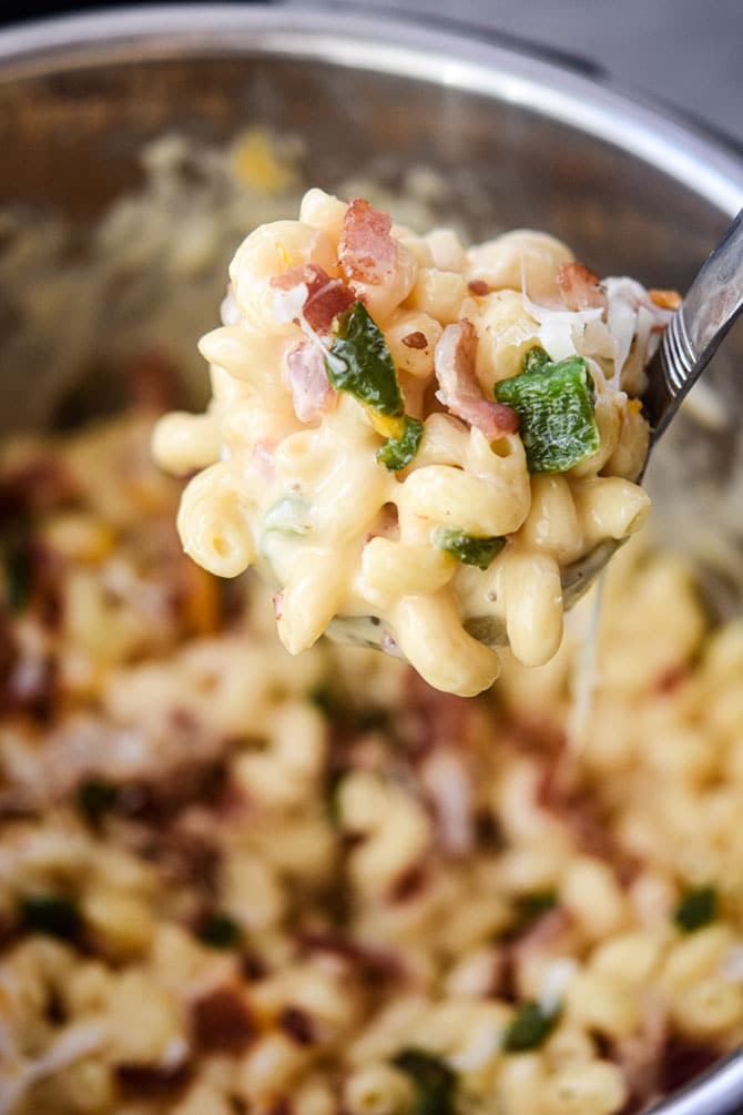 mac and cheese in a ladle close up with bacon