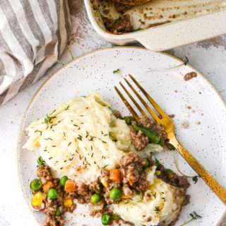 Shepards pie on a plate with gold fork