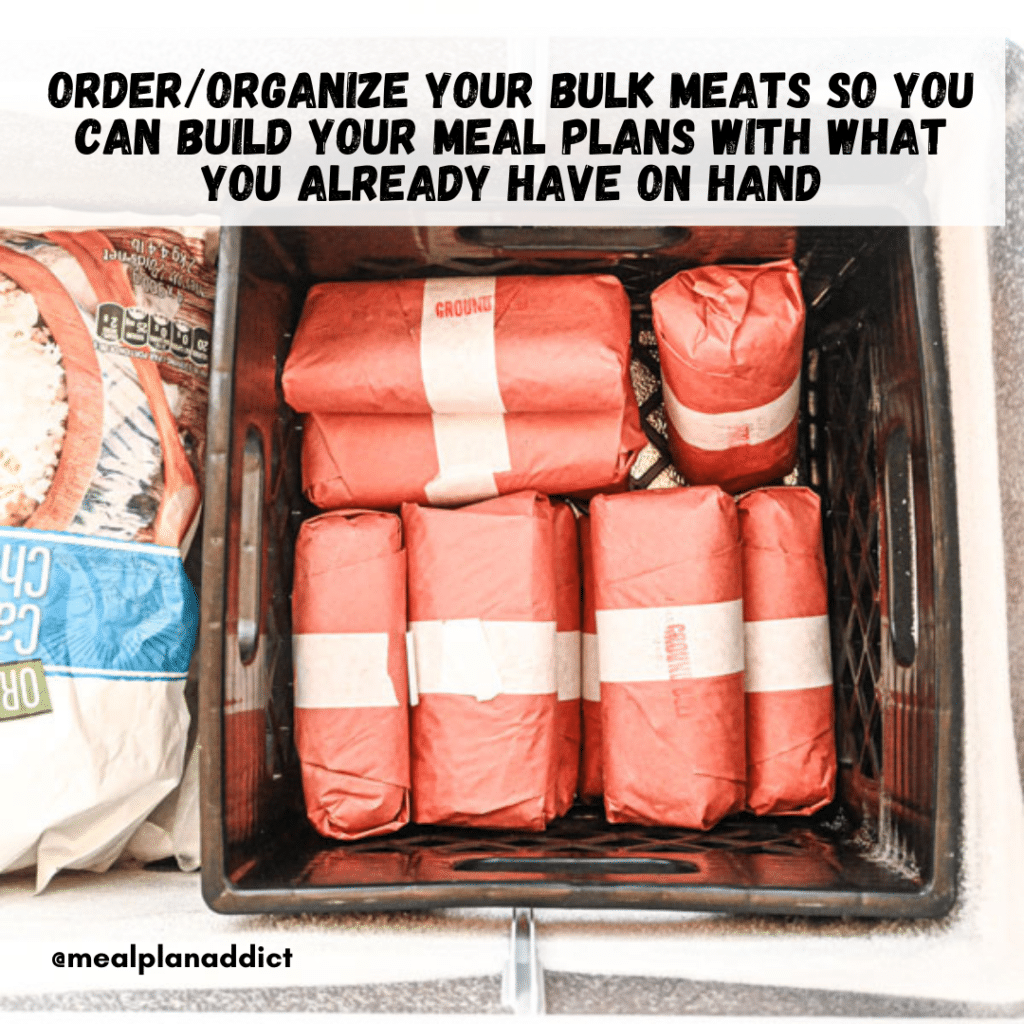 Bulk ground beef packages in a milk crate in a freezer. 