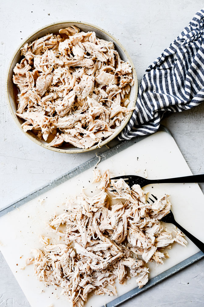 Shredded chicken on a cutting board with forks