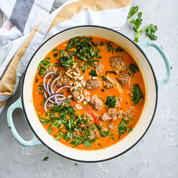 coconut curry meatballs simmering in sauce in Dutch oven