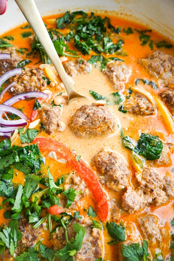 curry meatballs in sauce close up on spoon
