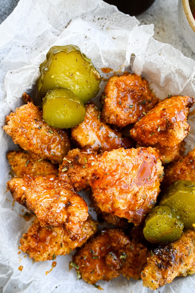 Hot honey chicken tenders in a basket with pickles