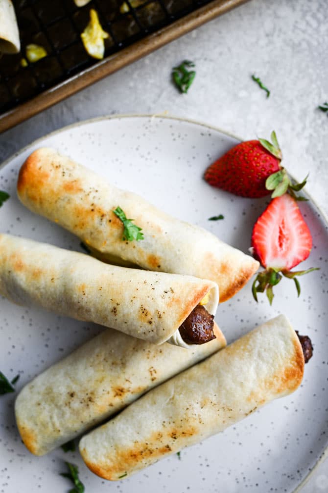 Crispy breakfast sausage taquitos baked on a plate